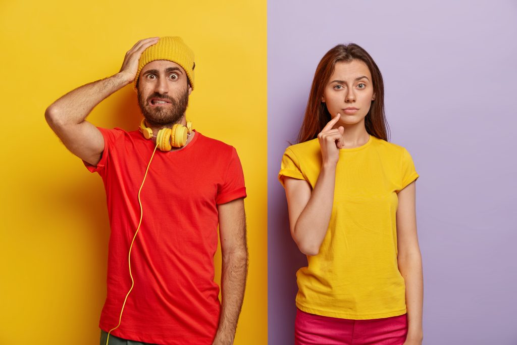 A man in a red shirt and yellow headphones looks confused, while a woman in a yellow shirt poses thoughtfully. The image represents contrasting reactions, symbolizing the importance of consistency in creativity and branding.